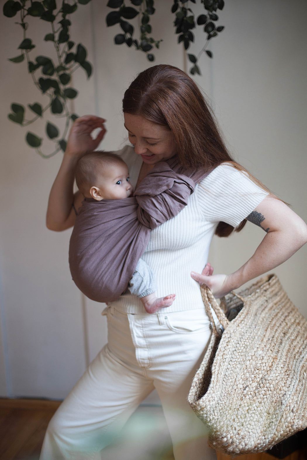 Mujer pelirroja con bebé en rebozo o bandolera